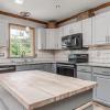 Kitchen remodel - painted tuxedo cabinets, granite countertop, handmade Spanish tile backsplash, new black stainless appliances, new LVP flooring, stained crown and trim, and new lighting design.